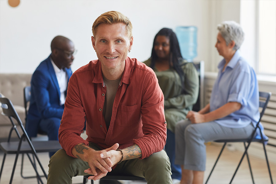 man sitting in front of group for addiction therapy