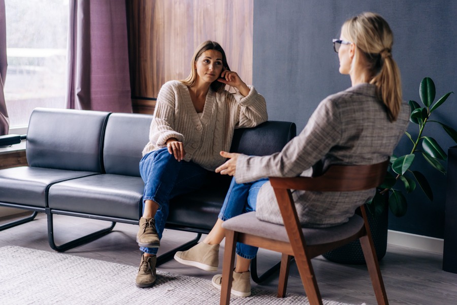 woman sitting in therapist's office talking about mental health