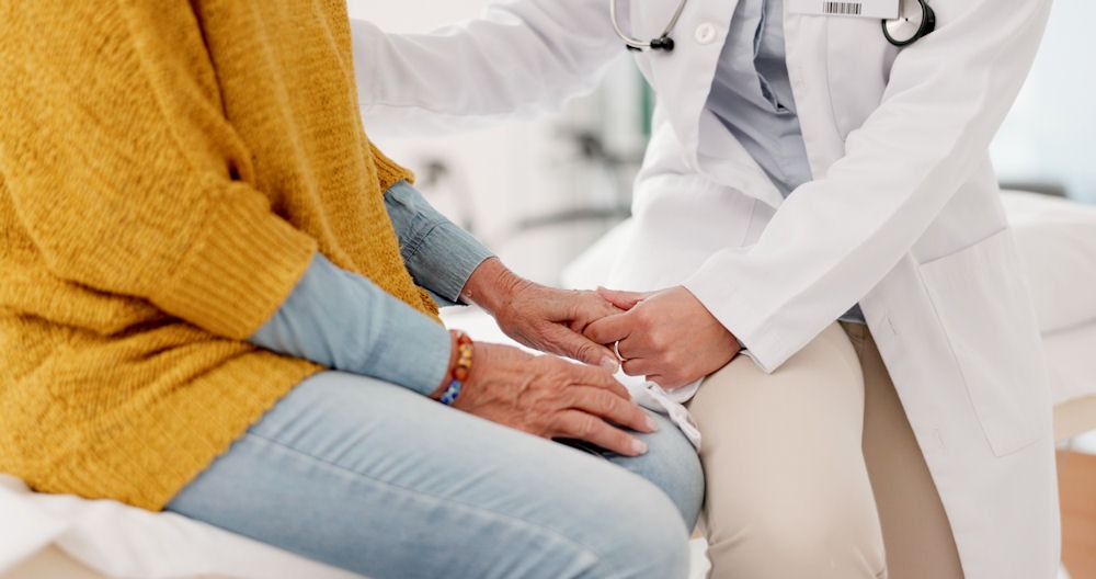 healthcare professional holding a patient's hand