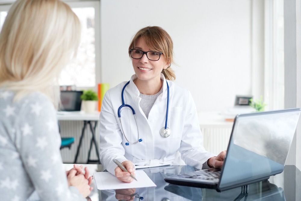  a health expert smiling while talking to her patient