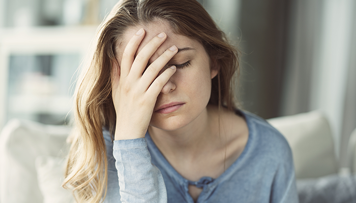 tired woman with her hand over her face