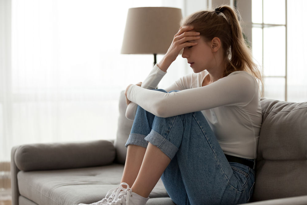 woman sitting on couch going through alcohol detox