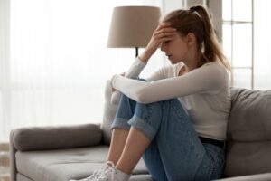 woman sitting on couch going through alcohol detox