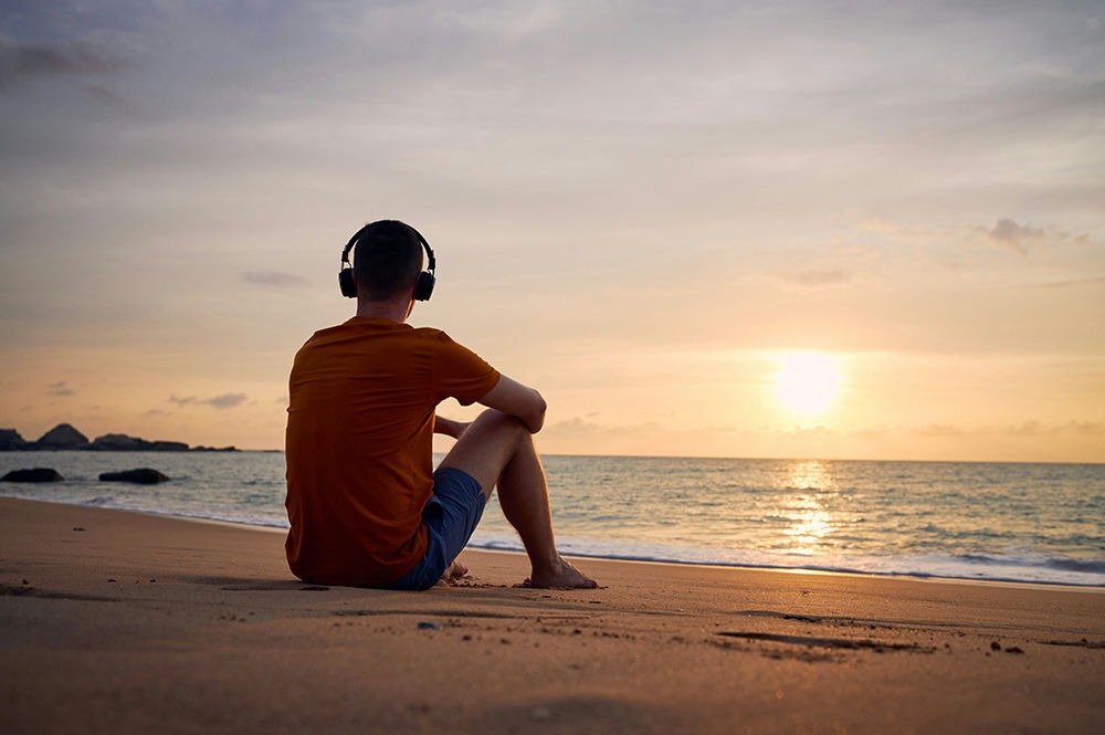 man on beach watching sunset