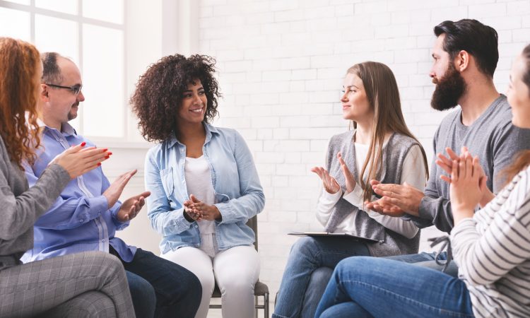 Common Success. Group of diverse people applauding to themselves at therapy session in rehab, celebrating their progress, panorama