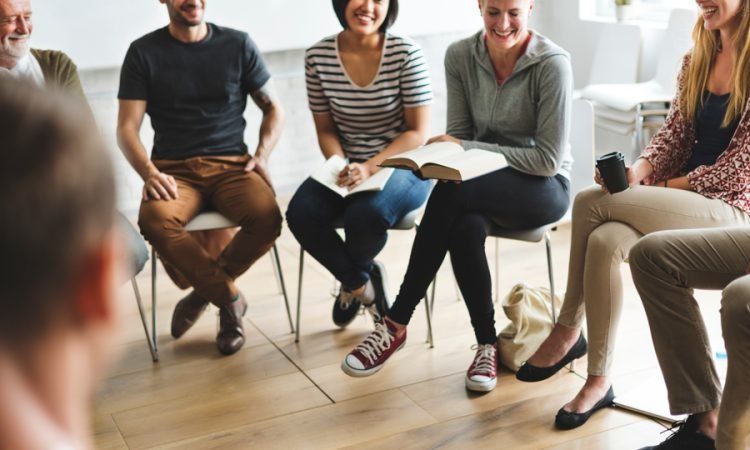 Several people of various backgrounds sitting in a circle, fostering discussion and collaboration